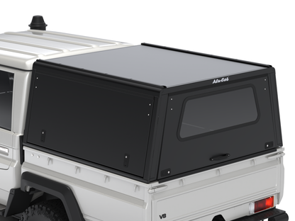 Hardtop Alu-Cab Explorer 3 pour Toyota Land Cruiser 79 Double-Cab, en aluminium, vue de face avec fenêtres et fixation.