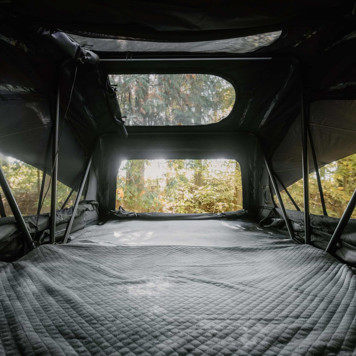 Tente de toit Voyage L GO OVERLAND CANADA pour 4 places, installation sur véhicule, tissu résistant et fenêtre zippée visible.