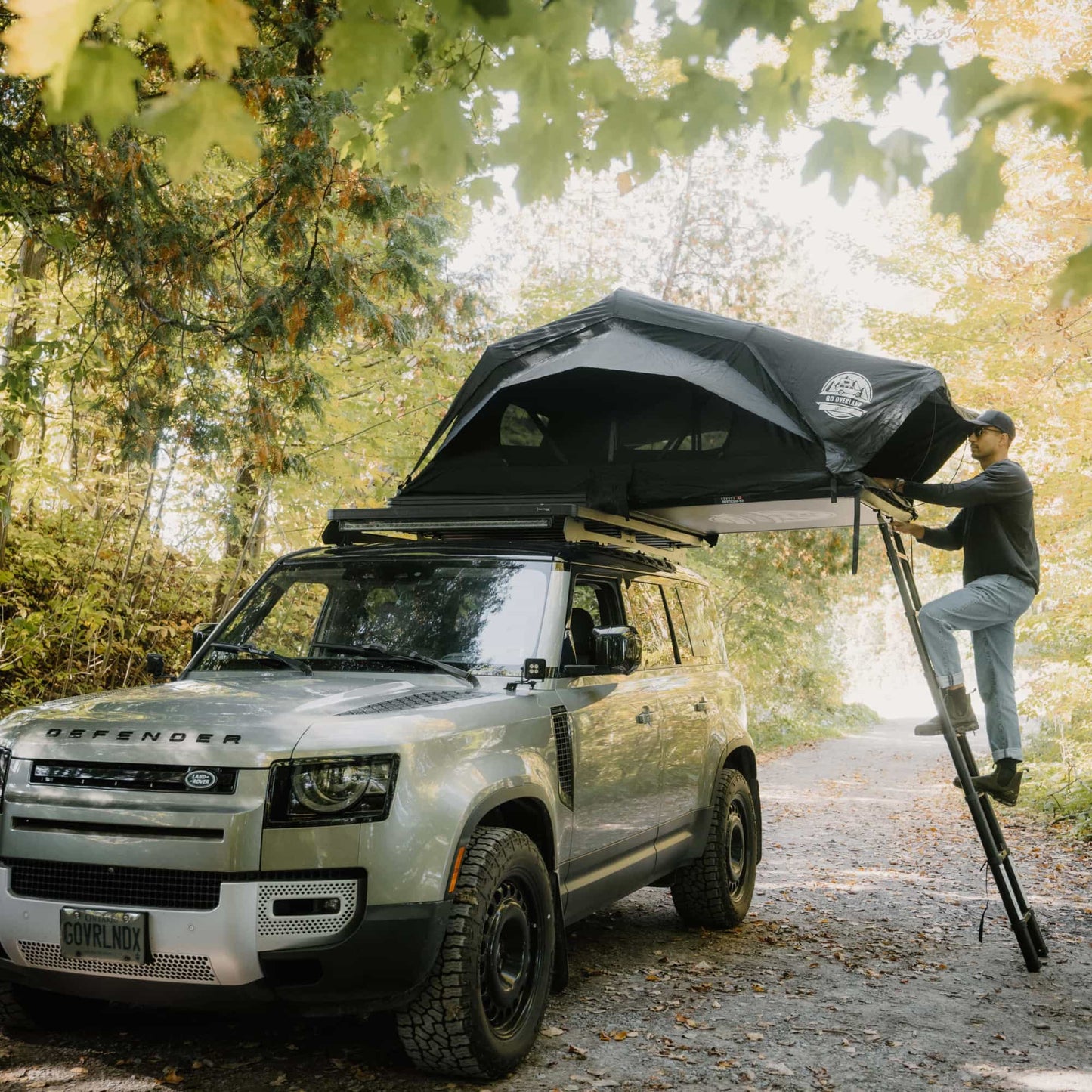 Tente de toit Voyage L GO OVERLAND CANADA pour 4 places, installation sur véhicule, tissu résistant et fenêtre en filet visible.